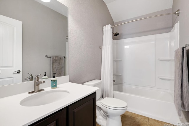 full bathroom featuring vanity, shower / tub combo with curtain, vaulted ceiling, tile patterned flooring, and toilet