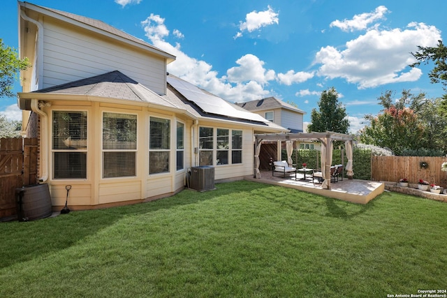 back of house featuring solar panels, a pergola, central AC, a yard, and a patio