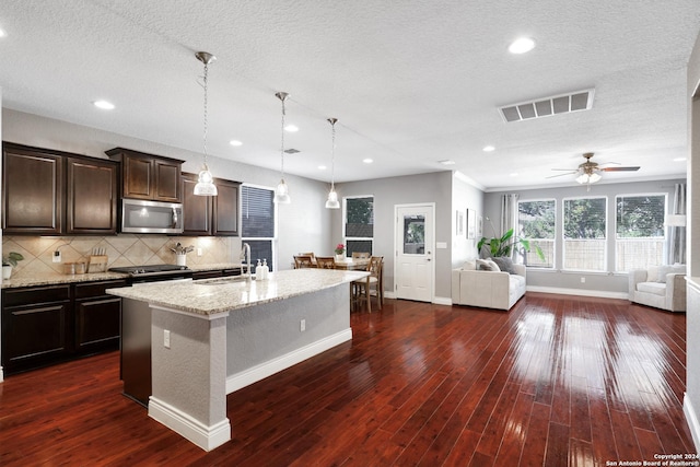 kitchen featuring a kitchen island with sink, dark wood-type flooring, sink, ceiling fan, and stainless steel appliances