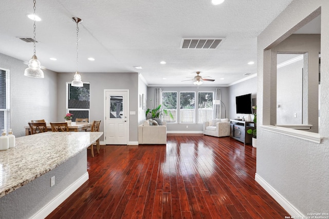 kitchen with crown molding, hanging light fixtures, dark hardwood / wood-style floors, ceiling fan, and a textured ceiling