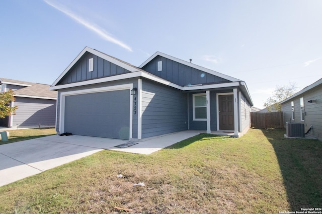 view of front facade featuring cooling unit, a garage, and a front lawn