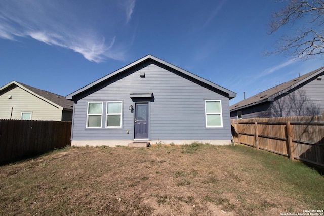 rear view of property featuring a yard