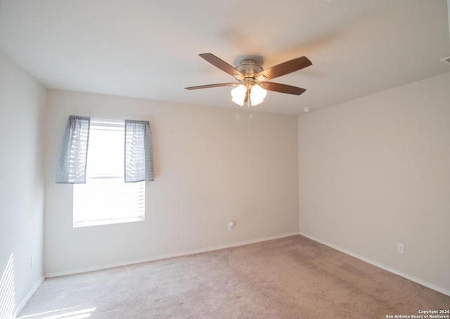 carpeted spare room featuring ceiling fan