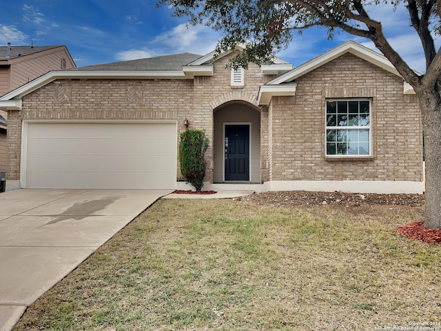 view of front of property with a front yard and a garage