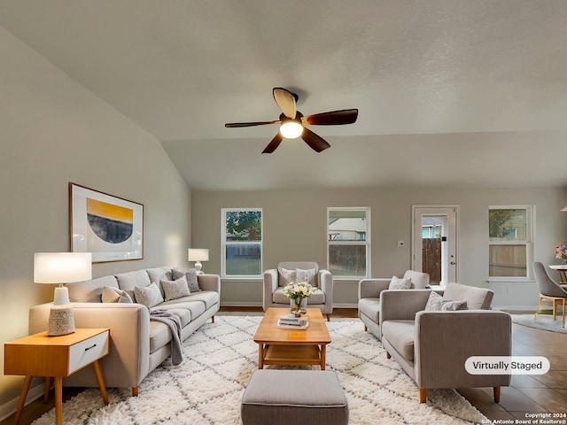 living room featuring ceiling fan, lofted ceiling, and light tile patterned floors