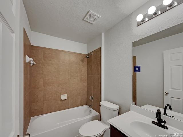 full bathroom featuring vanity, a textured ceiling, toilet, and tiled shower / bath