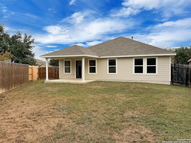 rear view of house featuring a patio area and a yard