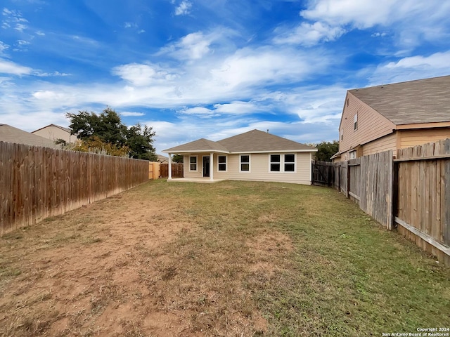 rear view of property featuring a lawn and a patio