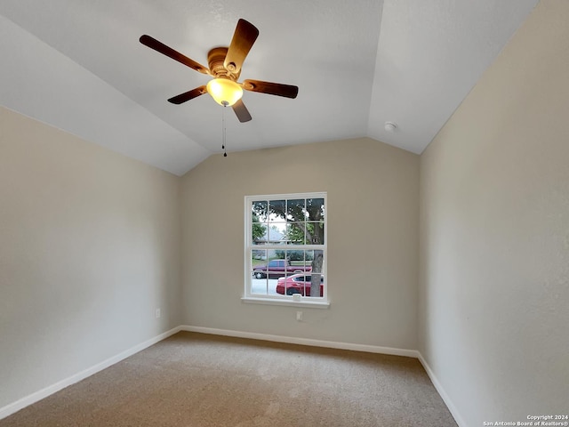 carpeted empty room with ceiling fan and vaulted ceiling