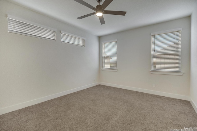 carpeted spare room featuring ceiling fan