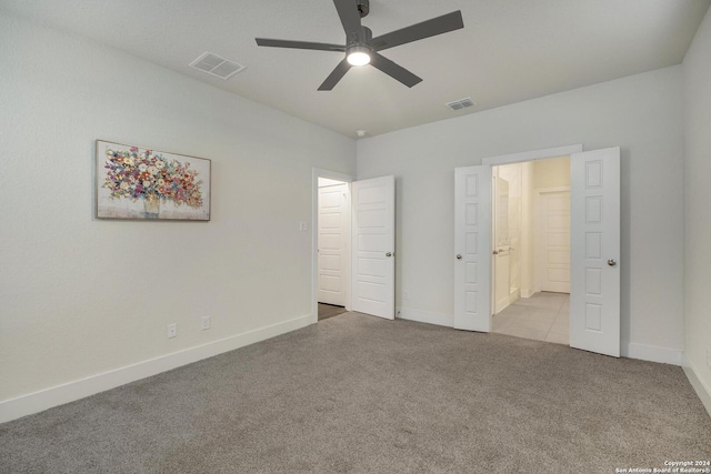 unfurnished bedroom with connected bathroom, light colored carpet, and ceiling fan