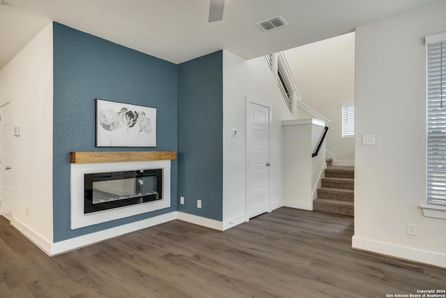 unfurnished living room featuring dark hardwood / wood-style floors and ceiling fan