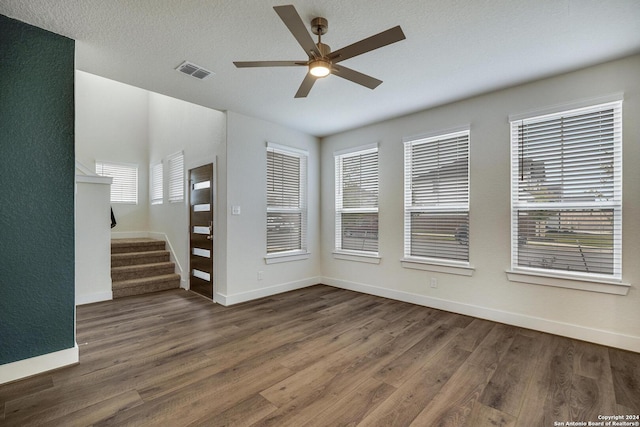 spare room with ceiling fan, dark hardwood / wood-style floors, and a textured ceiling