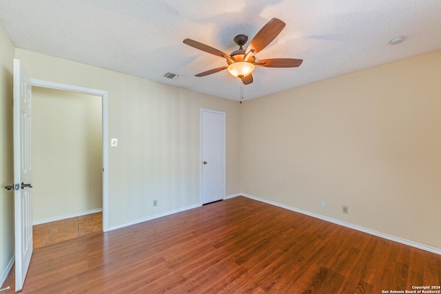 empty room featuring wood-type flooring and a textured ceiling