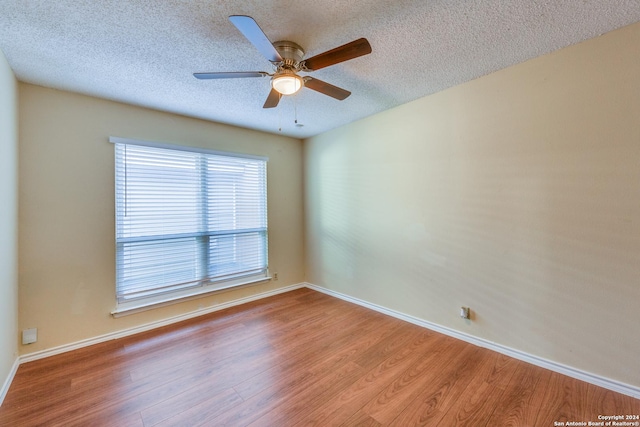 spare room with ceiling fan, light hardwood / wood-style flooring, and a textured ceiling