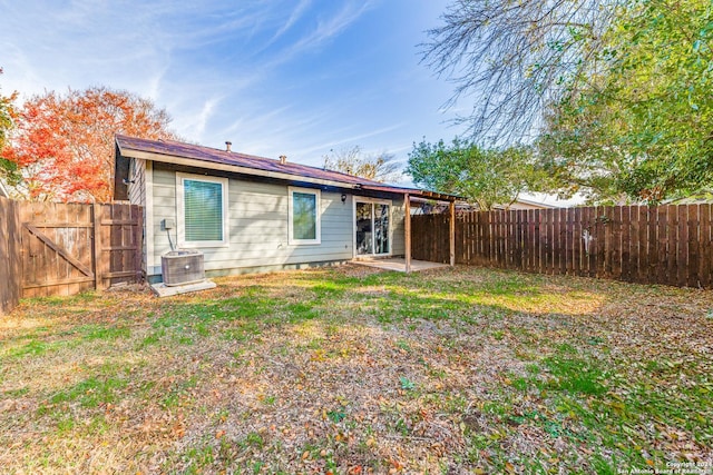 back of house featuring a lawn and central AC unit