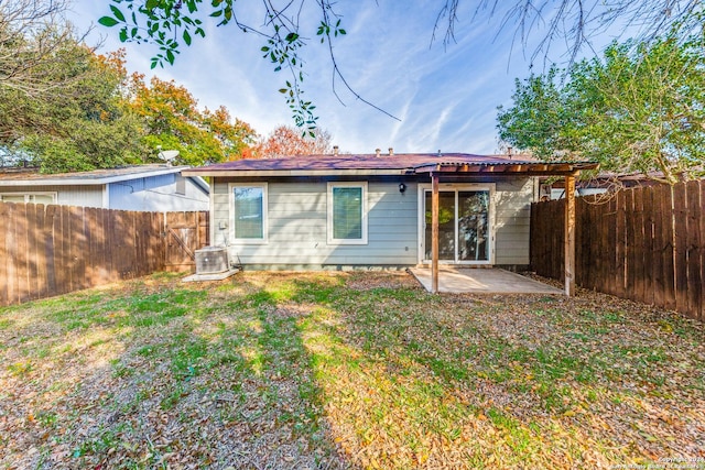 rear view of house with cooling unit, a yard, and a patio