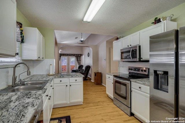 kitchen with white cabinets, light hardwood / wood-style floors, sink, and stainless steel appliances