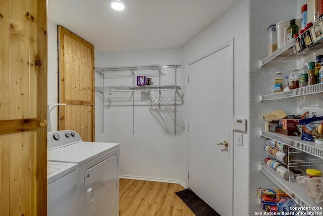 washroom with washer and clothes dryer and light hardwood / wood-style floors