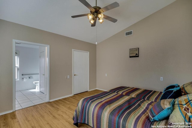 bedroom featuring ensuite bathroom, light hardwood / wood-style floors, lofted ceiling, and ceiling fan