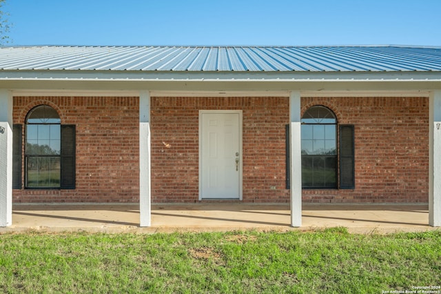 doorway to property featuring a lawn