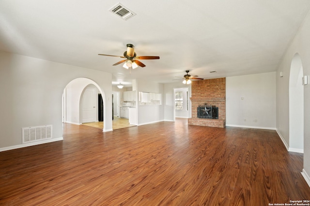 unfurnished living room with a fireplace, hardwood / wood-style flooring, and ceiling fan