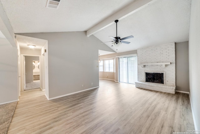 unfurnished living room featuring ceiling fan, a brick fireplace, vaulted ceiling with beams, light hardwood / wood-style floors, and a textured ceiling