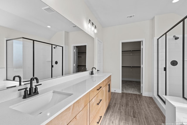 bathroom with vanity, vaulted ceiling, and a shower with door