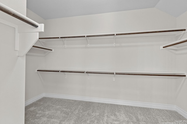 walk in closet featuring light carpet and vaulted ceiling