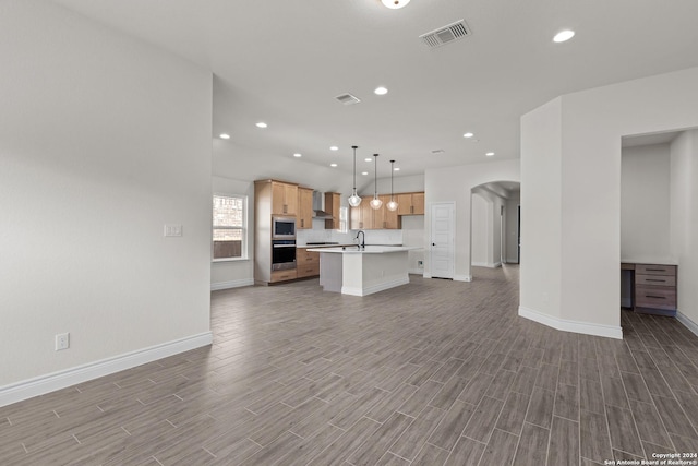 unfurnished living room with light hardwood / wood-style flooring and sink