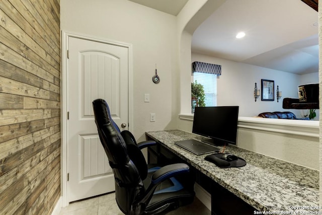 tiled office featuring wood walls