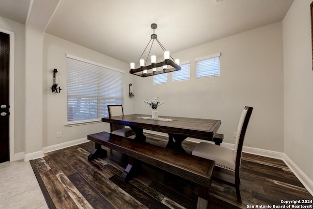 dining space featuring hardwood / wood-style flooring and a notable chandelier