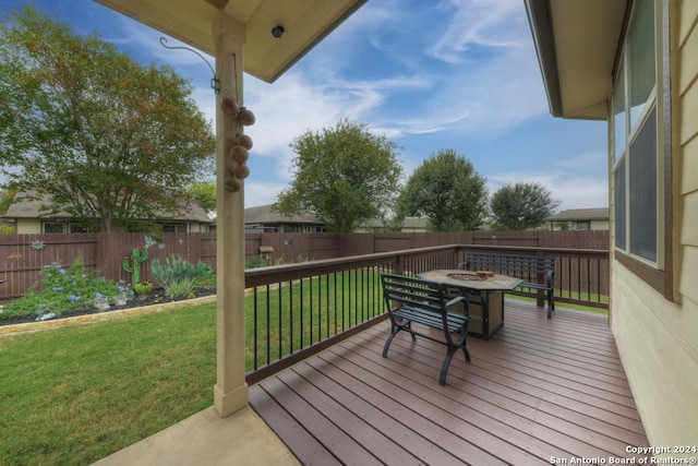 wooden deck featuring a fire pit and a yard