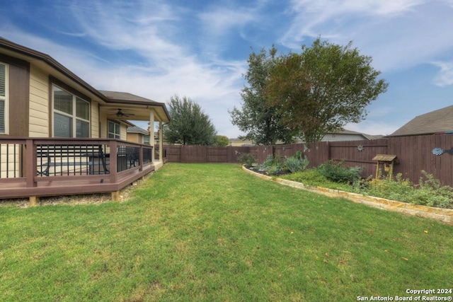 view of yard featuring ceiling fan and a wooden deck