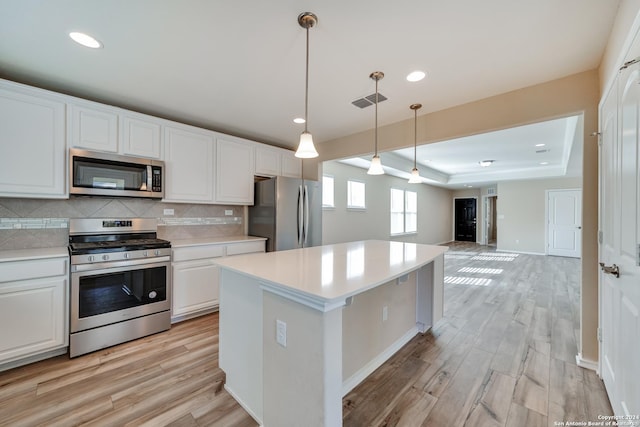 kitchen with light hardwood / wood-style flooring, white cabinets, and appliances with stainless steel finishes