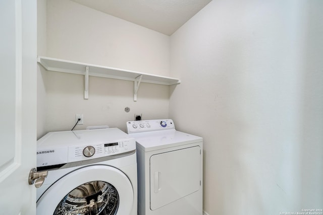 clothes washing area featuring washer and dryer and a textured ceiling