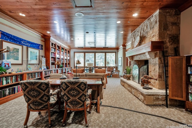 dining space featuring a stone fireplace, wooden ceiling, carpet floors, and ornamental molding