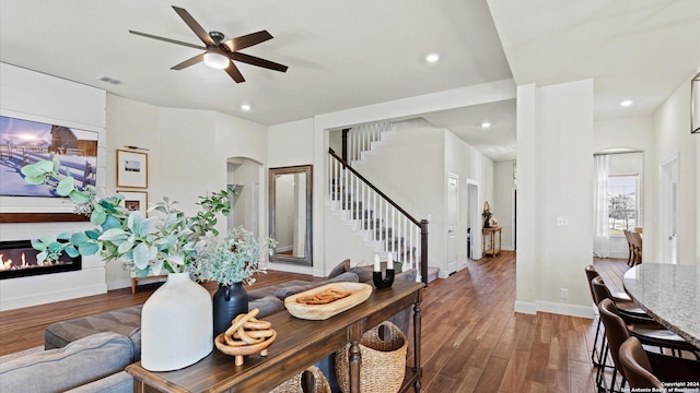 living room featuring a fireplace, ceiling fan, and dark hardwood / wood-style flooring