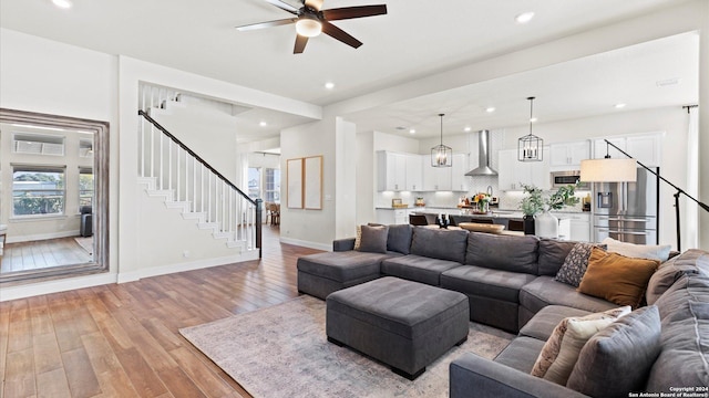 living room with light wood-type flooring and ceiling fan