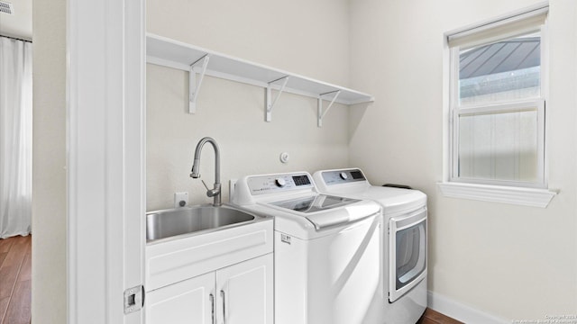 laundry area featuring dark hardwood / wood-style flooring, sink, and washing machine and dryer