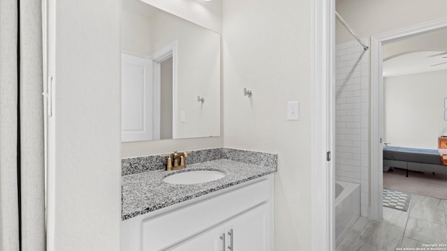 bathroom featuring ceiling fan, tile patterned flooring, vanity, and tiled shower / bath combo