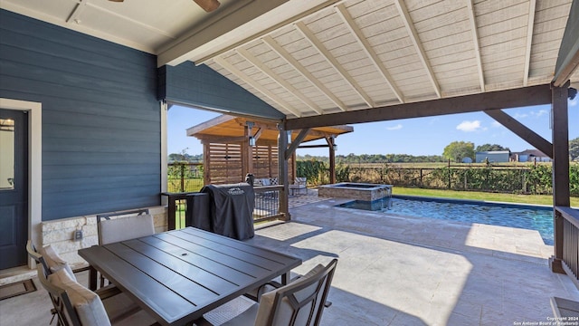 view of patio featuring ceiling fan and a pool with hot tub