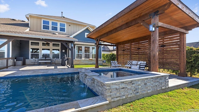 view of pool with an in ground hot tub, an outdoor hangout area, pool water feature, ceiling fan, and a patio