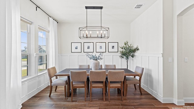 dining space with dark wood-type flooring and a notable chandelier