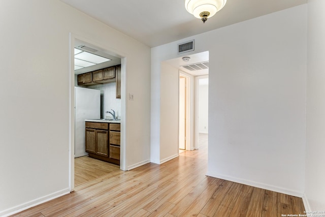 empty room featuring light hardwood / wood-style floors and sink