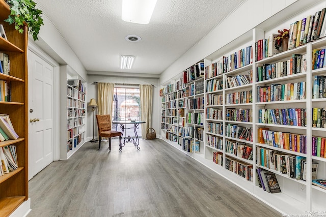 living area with hardwood / wood-style floors and a textured ceiling