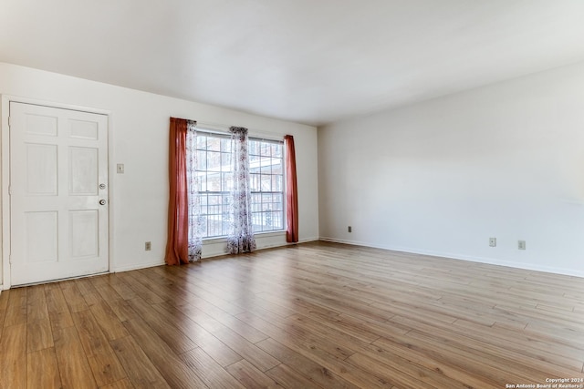 unfurnished room with light wood-type flooring