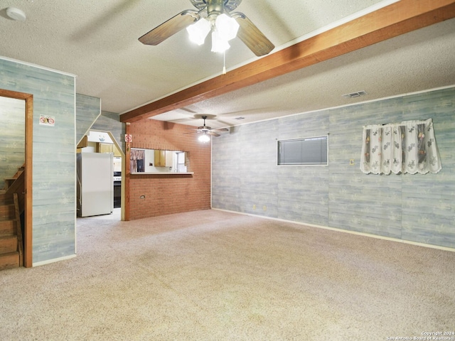 unfurnished living room with beam ceiling, carpet floors, and a textured ceiling