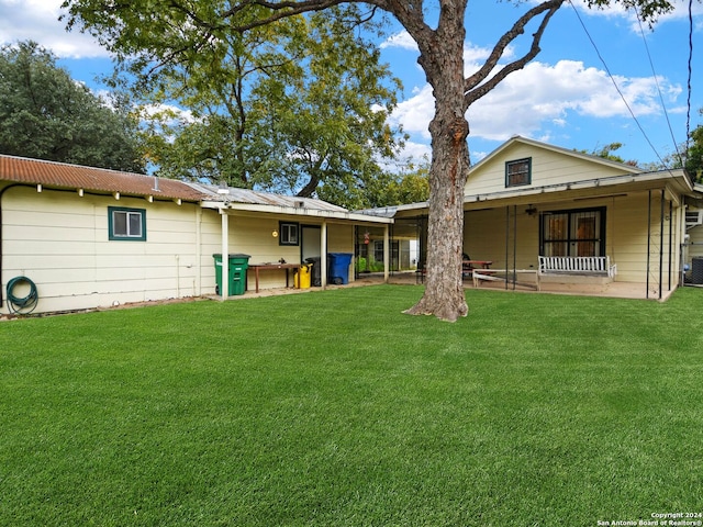 rear view of property featuring a patio area and a lawn