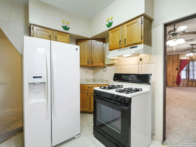 kitchen featuring white appliances, tasteful backsplash, ceiling fan, and wood walls